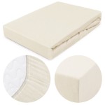 Prześcieradło jersey z gumką w kolorze ecru, w rozmiarze 180x200. Złożone, pokazane z góry. Boki z elastycznym obszyciem, materiał gładki i miękki w dotyku. Detal pokazujący fakturę dzianiny oraz wykończenie narożników.
