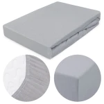 Prześcieradło jersey z gumką w kolorze popiel. Wymiary 200x220 cm, złożone, z widoczną gumką na krawędzi. Zbliżenie na fakturę materiału i detale wykończenia. Produkt leży na jednolitym tle, co podkreśla jego kolor i fakturę.