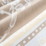Pościel satyna bawełniana 160x200 Satynlove w kolorze białym z beżowymi kwiatami, ukazana w zbliżeniu. Widoczne wzory kwiatowe oraz faktura materiału. Produkt leży na gładkim tle, ukazując detale tkaniny.