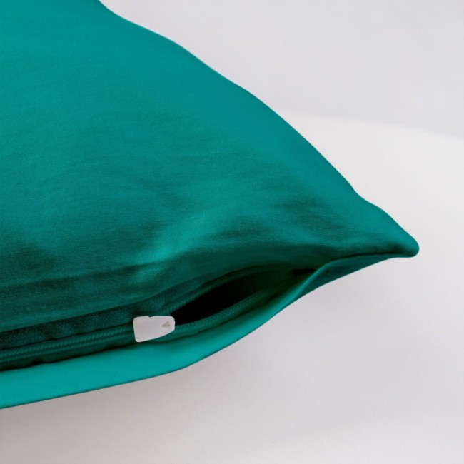 Poszewka satynowa 50x70 w kolorze ciemnego turkusu, leżąca na jednolitym tle. Zamek błyskawiczny widoczny w dolnej części poszewki, gładka faktura materiału. Idealna do dekoracji poduszek w sypialni lub salonie.