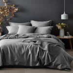 Poszewka satynowa 50x70 w kolorze popielatym, leżąca na łóżku pościelowym. Produkt wykonany z gładkiego materiału, idealnie dopasowany do poduszki. Tło w odcieniach szarości, z dodatkowymi poduszkami i dekoracjami w minimalistycznym stylu.