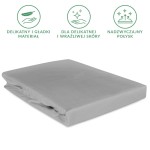 Prześcieradło satynowe w kolorze popielatym, o wymiarach 120x200 cm, leżące na płaskiej powierzchni. Materiał gładki i błyszczący, z gumką. Widoczne ikony informujące o delikatności i przeznaczeniu dla wrażliwej skóry. Proste tło.