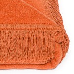 Koc bawełniany 150x200 cm w intensywnym pomarańczowym kolorze, z frędzlami na brzegach. Dodany w widoku z góry, leżący na białym tle, prezentujący teksturę materiału oraz staranne wykończenie.