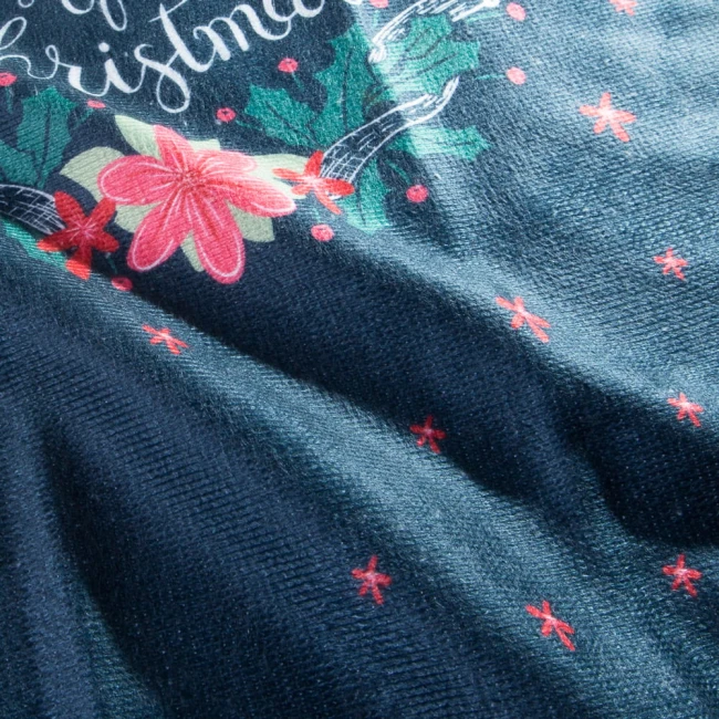 Ścierka kuchenna w odcieniu ciemnego granatu, z wzorem świątecznym, w tym czerwone kwiaty i liście ostrokrzewu. Widoczny napis Merry Christmas. Produkt leży na płaskiej powierzchni, tło jasne. Wymiary 38x60 cm.