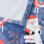 Ścierka kuchenna w zestawie 2 sztuki o wymiarach 38x60 cm, z nadrukiem Świętego Mikołaja i reniferów na ciemnoniebieskim tle. Produkt z podszewką o strukturze frote, z widoczną, estetyczną nicią. Leży na płaskiej powierzchni, widok z góry.