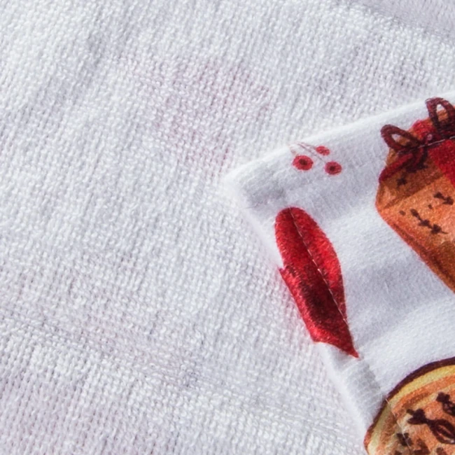 Ścierka kuchenna w białym kolorze z zielonymi elementami świątecznymi. Ujęcie z bliska ukazuje fragment wzoru z motywami bożonarodzeniowymi, takimi jak czerwone serca i prezenty. Materiał jest teksturowany, a rozmiar to 38x60 cm.