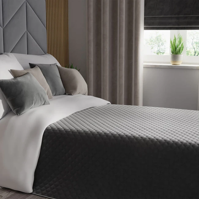 Poszewka dekoracyjna Velvi 40x40 cm w ciemnoszarym kolorze, wykonana z welwetu. Kąt ujęcia frontalny, poszewka leży na łóżku obok poduszek o różnych odcieniach szarości. W tle zasłony i okno z rośliną doniczkową. Produkt w aranżacji sypialni.