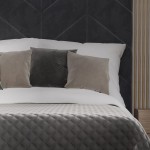 Poszewka welwetowa 40x40 w kolorze ciemno szarym, umieszczona na łóżku, z miękkim, teksturowanym wykończeniem.