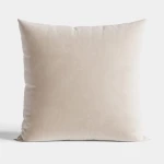 Poszewka dekoracyjna Velvi 40x40, kremowa, wykonana z welwetu. Produkt leży na białym tle, ukazując miękką fakturę materiału. Brak dodatkowych wzorów czy napisów, co podkreśla prostotę stylu.