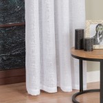 Biała firana na przelotkach z etaminy, gładka, o wymiarach 140x250 cm. Zawieszona w pomieszczeniu, z widoczną strukturą tkaniny. W tle stolik z dekoracjami i świecami w odcieniach czerni.