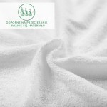 Prześcieradło frotte z gumką 140x200, wykonane z białego materiału. Ujęcie z bliska, pokazujące fakturę tkaniny. Widoczny nadruk informujący o odporności na przecieranie i rwanie materiału. Produkt leży, rozłożony na tle o jednolitym kolorze.