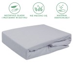 Prześcieradło frotte z gumką 140x200 w kolorze popielatym, leżące w pozycji złożonej. Materiał teksturowany, elastyczny. Widoczna gumka utrzymująca je na materacu. Tło białe, co podkreśla kolor i fakturę produktu.