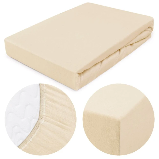 Prześcieradło jersey z gumką w kolorze jasnego beżu, rozmiar 200x220 cm. Widoczny detal gumki oraz tekstura materiału. Produkt leżący na białym tle, zbliżenie na krawędź oraz fakturę, ukazujące wysoką jakość wykonania.