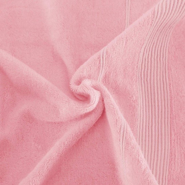 Ręcznik bambusowy 50x90 cm w kolorze różowym, o miękkiej, teksturowanej powierzchni. Widoczne delikatne wzory i przeszycia wzdłuż krawędzi. Produkt leży w luźnym ułożeniu, ukazując jego elastyczność i fakturę.