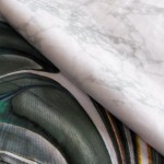 Pościel satyna bawełniana 220x200 w kolorze szaro-beżowym z abstrakcyjnym wzorem, rozłożona na płaskiej powierzchni. Materiał gładki, z subtelnymi akcentami kolorystycznymi. Tło białe, co podkreśla detale wzoru. Produkt nowy, z widocznymi fałdami.