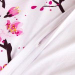 Pościel satynowa 180x200 z białym tłem, na której widoczne kwiaty wiśni w odcieniach różu i czerni. Zamek błyskawiczny widoczny na boku poszwy. Produkt leży na płasko, ukazując detale wzoru i fakturę materiału.