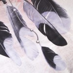 Pościel w satynowej bawełnie o wymiarach 140x200 cm, w fioletowo-różowym kolorze. Wzór przedstawia łapacz snów z czarnymi i szarymi piórami na jasnym tle, z subtelnymi detalami w postaci szarych i białych koralików.