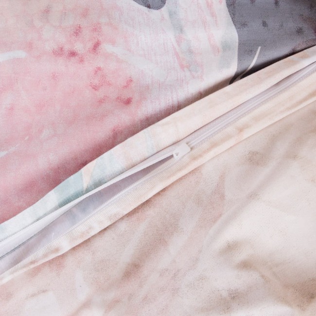 Pościel satynowa 220x200 cm w fioletowo-różowe wzory z motywem łapacza snów. Widoczny zamek błyskawiczny na poszewce. Materiał miękki, z subtelną fakturą, idealny do sypialni.