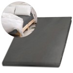 Prześcieradło satynowe bez gumki 160x220 w kolorze szarym, leżące na jednolitym tle, z widoczną gładką fakturą. W tle fragment łóżka z białymi poduszkami. Produkt rozłożony, idealny do aranżacji sypialni.