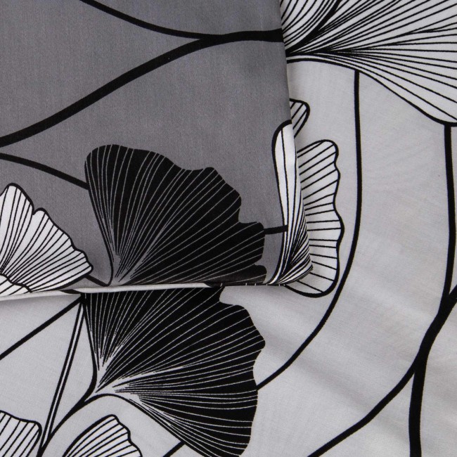 Pościel satyna bawełniana 200x220 cm w kolorze białym z wzorem czarno-białych liści miłorzębu. Złożona, ukazująca detale tkaniny i wzoru, o gładkiej fakturze. Idealna do nowoczesnej sypialni.