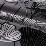 Pościel satynowa bawełniana 200x220 cm w kolorze białym z czarno-białym wzorem liści miłorzębu. Materiał gładki, z wyraźnym nadrukiem, ułożona w delikatne fałdy, ukazując detale wzoru i teksturę tkaniny.