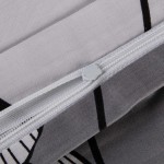 Zbliżenie na zamek błyskawiczny pościeli satynowej bawełnianej 200x220 cm w kolorze białym z czarno-białymi liśćmi miłorzębu. Widoczna jest faktura materiału oraz detale wykończenia. Pościel ma matowy wygląd i elegancki wzór roślinny.