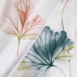 Pościel satyna bawełniana 180x200 w białym kolorze z pastelowymi liśćmi. Widoczne liście w odcieniach różu i zieleni, z delikatnymi detalami. Tkanina gładka, bez widocznych napisów, ułożona w sposób ukazujący wzór.