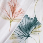 Pościel satyna bawełniana 220x200 w pastelowe liście, w kolorze białym z delikatnym nadrukiem. Złożona, widok z góry, pokazująca szczegóły liści w odcieniach zieleni i różu. Tło jednolite, co podkreśla wzór. Przyjemny materiał i elegancki design.