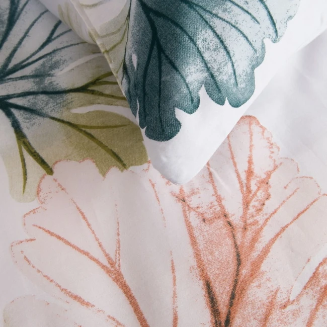 Pościel satyna bawełniana 220x200 Satynlove w białym kolorze z pastelowymi liśćmi w odcieniach zieleni i brązu. Widok z góry na złożoną pościel z poduszką. Tło jasne, co podkreśla wzory na materiale, który jest gładki i delikatny w dotyku.