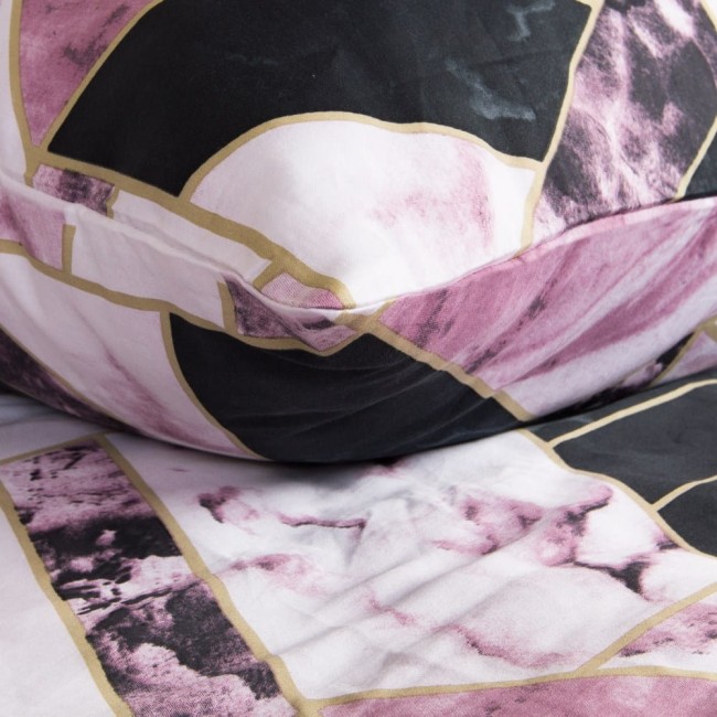 Pościel satynowa 180x200 cm w kolorze czarno-różowym, z geometrycznym wzorem marmurowym. Widoczna jest poduszka i fragment poszwy, z wyraźnymi, różowymi i czarnymi motywami, oddzielonymi złotymi liniami. Materiał gładki, błyszczący.