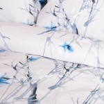 Pościel satyna bawełniana 220x200 w jasnym odcieniu z pastelowymi błękitnymi kwiatkami. Wzór kwiatowy na białym tle, z widocznymi detalami roślinnymi. Położona w złożeniu, z widoczną poszewką na poduszkę i kołdrę.