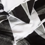 Pościel bawełniana 220x200 w biało-czarny wzór symetrycznych rombów. Materiał o gładkiej fakturze, rozłożony na płaskiej powierzchni, ukazujący detale wzoru oraz kolory. Brak widocznych napisów lub logo.