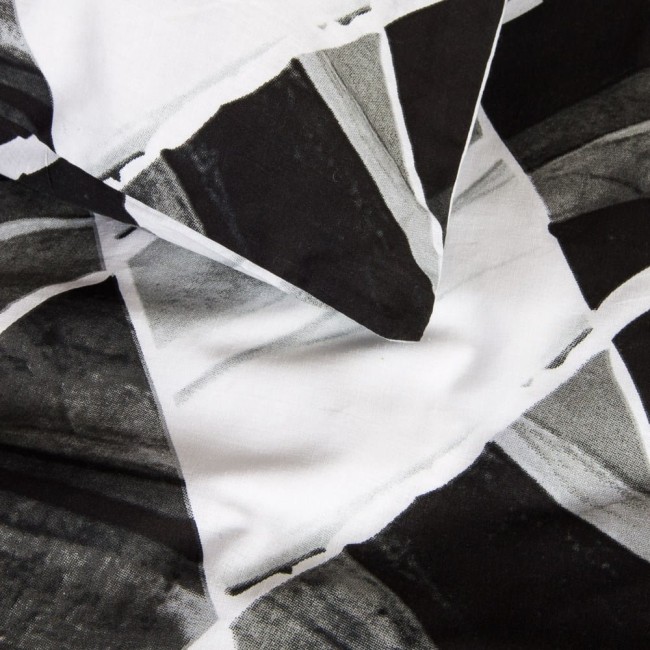 Pościel bawełniana 220x200 w biało-czarny wzór symetrycznych rombów. Materiał o gładkiej fakturze, rozłożony na płaskiej powierzchni, ukazujący detale wzoru oraz kolory. Brak widocznych napisów lub logo.