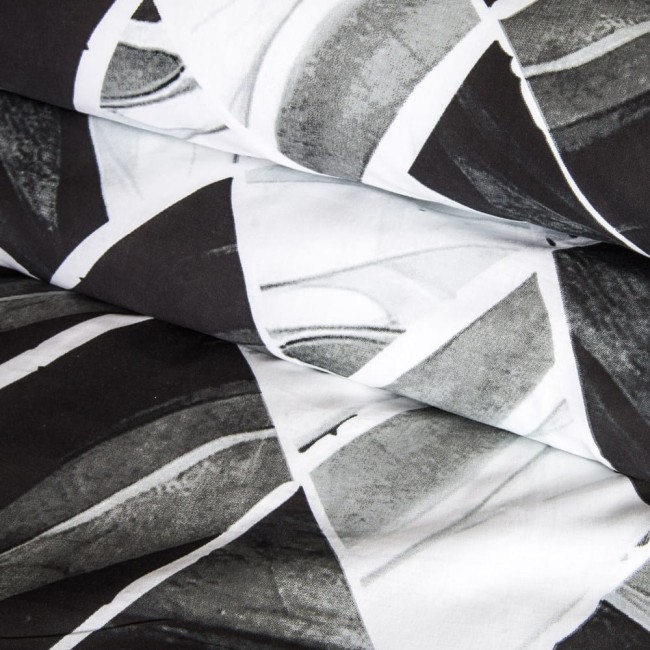 Pościel bawełniana 220x200 w biało-czarny wzór symetrycznych rombów. Złożona, ukazująca detale faktury tkaniny. Tło neutralne, co podkreśla wzór. Przykład nowoczesnego designu do sypialni.