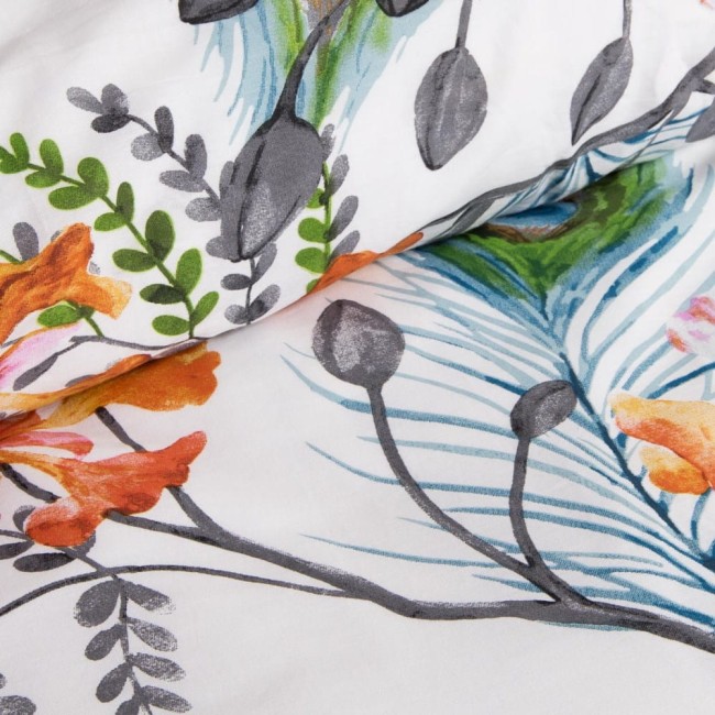 Pościel bawełniana 140x200 Cottonlove w kolorze białym, zdobiona tropikalnymi pomarańczowymi kwiatami oraz zielonymi liśćmi. Pozycjonowana w rozłożonej formie, zbliżenie na detale wzoru, na jasnym tle. Tekstura tkaniny gładka.