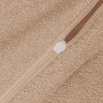 Beżowa pościel frotte 160x200 z bliska, ukazuje fakturę materiału oraz zamek błyskawiczny w jasnym kolorze. Widoczny jest detal dzianiny, co podkreśla jej miękkość i komfort użytkowania. Tło jest jednolite, co uwydatnia produkt.