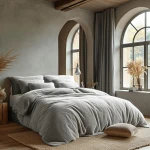 Pościel frotte w kolorze popiel, rozmiar 160x200 cm, leżąca na łóżku. Pokrycie ma miękką, teksturowaną powierzchnię, z widocznymi poduszkami w podobnej barwie.