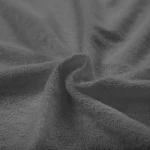 Pościel frotte w kolorze szarym o wymiarach 160x200, zmięta i rozłożona, ukazująca teksturę materiału. Widoczne niejednolite wzory frotte oraz interesujący układ fal. Tło jednolite, co podkreśla kolor produktu.