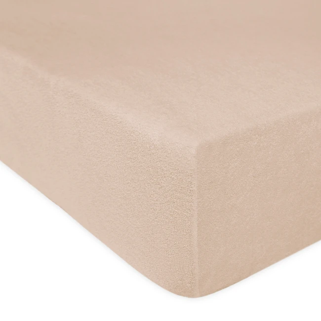Prześcieradło frotte z gumką 120x200 w kolorze beżowym, leżące na płaskiej powierzchni. Widać teksturę materiału oraz gumkę zabezpieczającą. Tło jest jednolite, co podkreśla kolor produktu. Brak widocznych napisów lub logo.