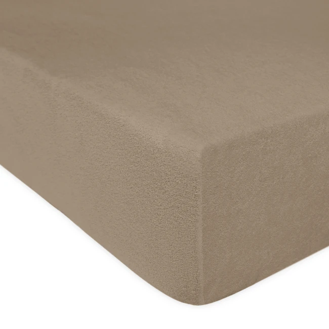 Prześcieradło frotte z gumką w kolorze kakao, w ujęciu z boku. Widoczna tekstura materiału, zapewniająca elastyczność i dopasowanie do materaca o wymiarach 120x200. Produkt leży na płaskiej powierzchni, co podkreśla jego rozmiar i kształt.