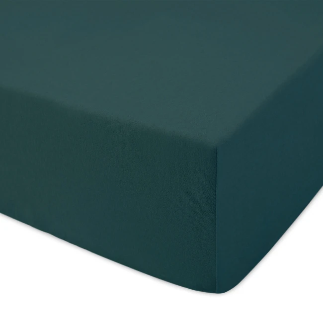 Prześcieradło jersey z gumką 120x200 w kolorze zieleni butelkowej, leżące na białym tle. Materiał o gładkiej, elastycznej fakturze dobrze dopasowuje się do materaca. Widoczna gumka zapewnia stabilne trzymanie na łóżku. Brak wzorów czy logo.