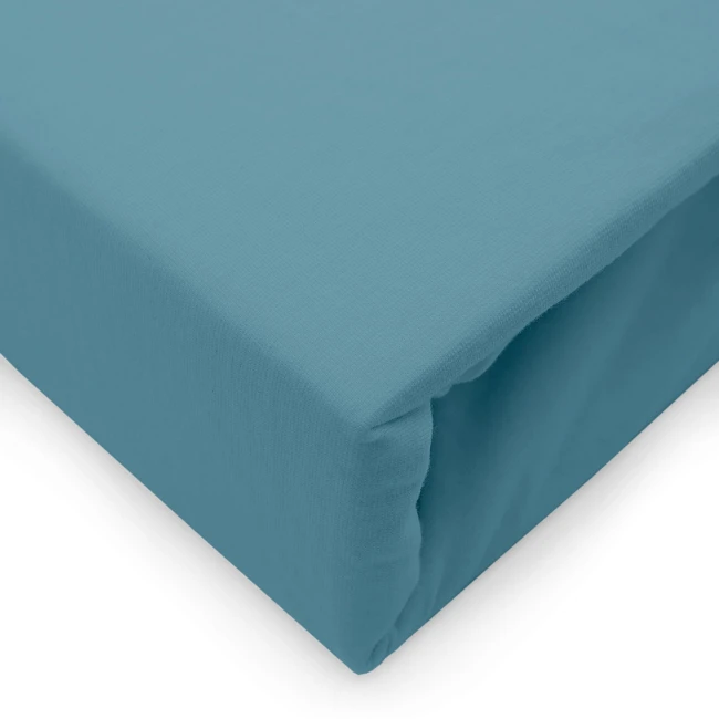 Prześcieradło jersey z elastanem 140x200 w kolorze błękitnym, leżące na prostym tle. Widoczna gumka zapewniająca mocowanie na materacu. Gładka, elastyczna faktura materiału, bez widocznych wzorów ani napisów.