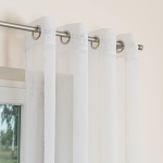 Firana gotowa na srebrnych przelotkach ETAMINA, biała, o wymiarach 140x250 cm, zawieszona na karniszu. Tkanina jest lekka, półprzezroczysta, z delikatną strukturą.