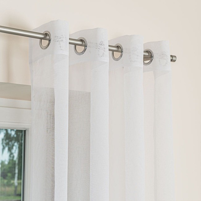 Firana gotowa na srebrnych przelotkach ETAMINA, biała, o wymiarach 140x250 cm, zawieszona na karniszu. Tkanina jest lekka, półprzezroczysta, z delikatną strukturą.
