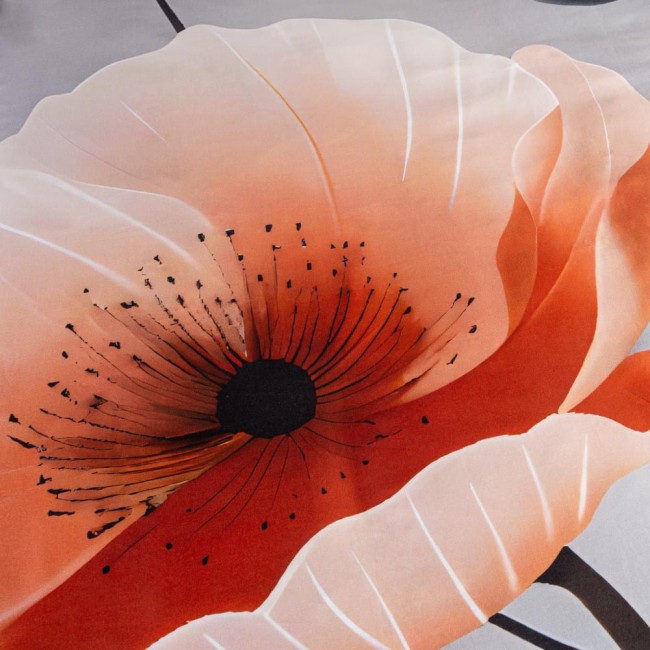 Detale pomarańczowego kwiatu ze wzorem na szarej tkaninie pościeli satynowej. Kwiat ma jaskrawy środek w czerni oraz cienkie, czarne pręciki. Zdjęcie w zbliżeniu, ukazuje szczegóły wzoru i fakturę materiału.