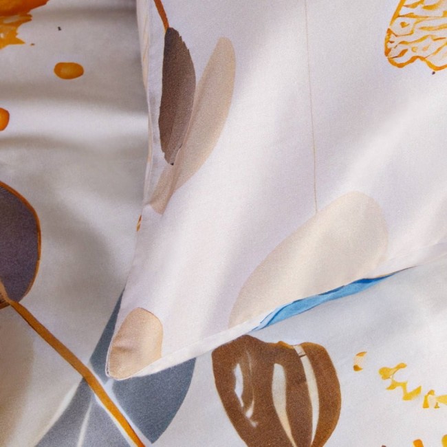 Pościel satyna bawełniana 160x200 w kolorze kremowym z niebieskimi motylami, złożona z poduszką w zbliżeniu. Widoczne wzory motyli na gładkiej, błyszczącej tkaninie. Pozycja leżąca, na jasnym tle. Tekstura delikatna, wizualnie elegancka.