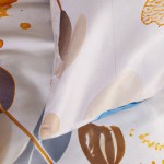 Pościel satynowa w kremowym kolorze, 180x200 cm, z niebieskimi motylami i abstrakcyjnymi wzorami. Złożona, z widocznym detalem na poduszce, prezentująca gładką, błyszczącą teksturę materiału. Tło jasne, zapewniające kontrast i czytelność wzoru.