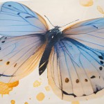Widok z bliska na detal niebieskiego motylka na pościeli satynowej, z kremowym tłem i złotymi akcentami. Motyl ma dużą, lekko przezroczystą skrzydło z ciemnymi kropkami oraz subtelne odcienie błękitu i żółtego. Dobrze widoczny wzór.