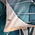 Pościel satyna bawełniana 160x200 Satynlove Premium, z motywem liści w odcieniach złotych i turkusowych, leżąca na gładkiej powierzchni. Widoczne detale krawędzi i faktura materiału, z podkreśloną kolorystyką wzoru na tle.