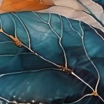 Pościel satyna bawełniana 220x200 w kolorze turkusowym i złotym z motywem liści. Ujęcie z góry, pokazujące szczegóły wzoru.